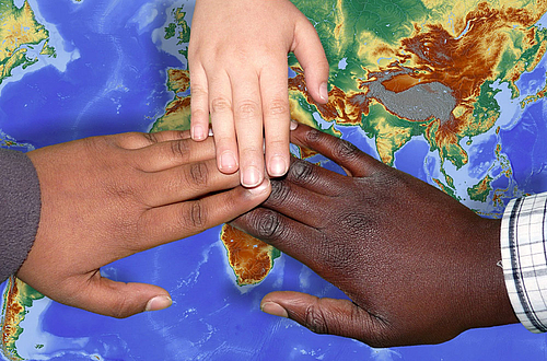 Hände auf Weltkarte